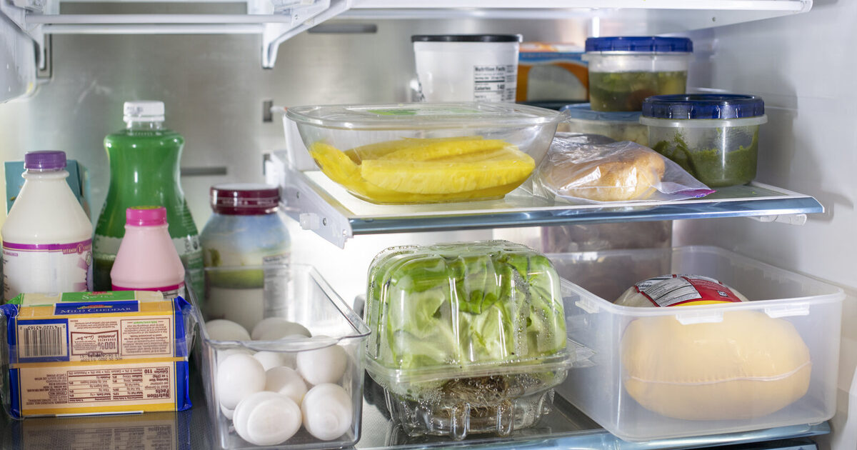 A real refrigerator containing sealed leftovers, dairy, eggs, produce, bread, and cheese